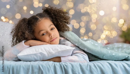 African american child girl, pensive and  upset laying on pillow in a bedroom, sad kid concept photo