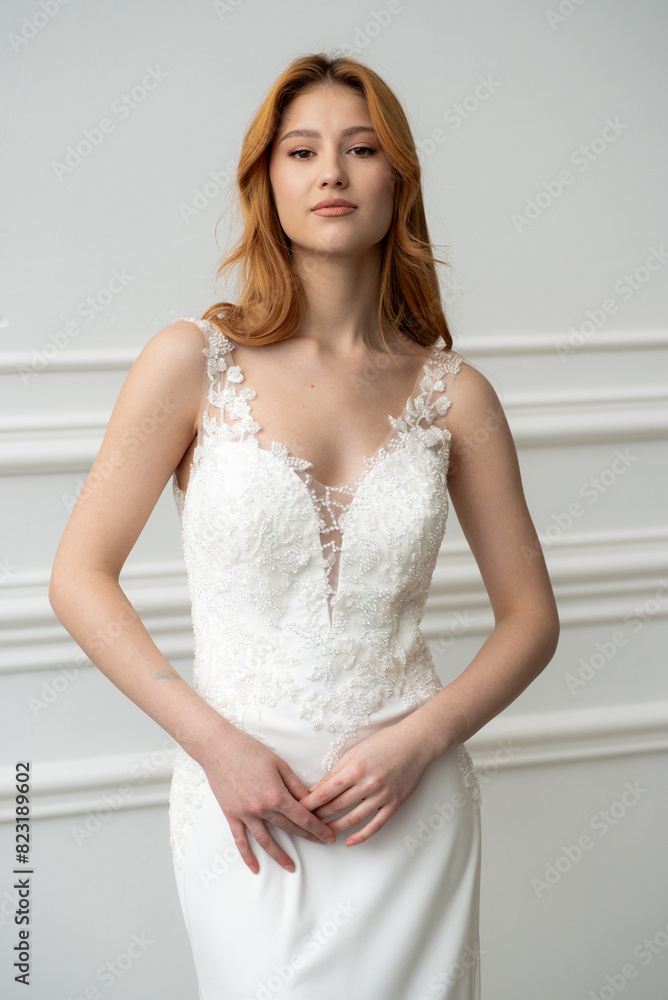 Beautiful young woman bride in fashion wedding dress in white interior Beautiful young woman bride in fashion wedding dress in white interior