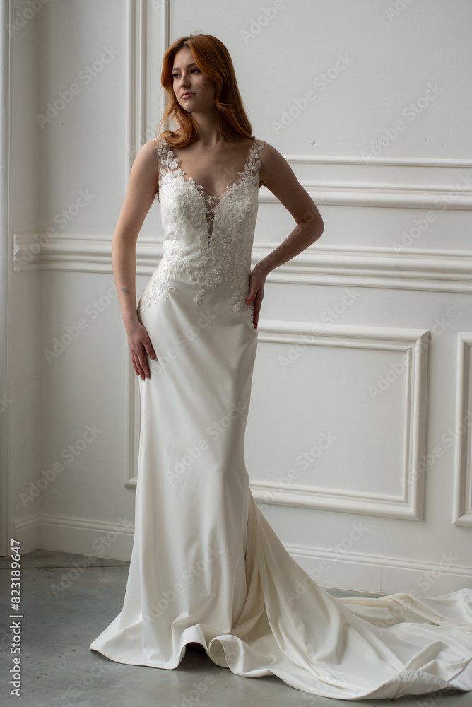Beautiful young woman bride in fashion wedding dress in white interior Beautiful young woman bride in fashion wedding dress in white interior