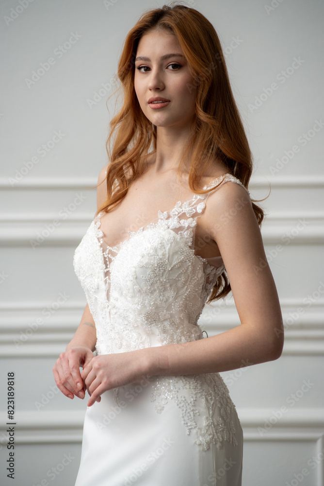 Beautiful young woman bride in fashion wedding dress in white interior Beautiful young woman bride in fashion wedding dress in white interior