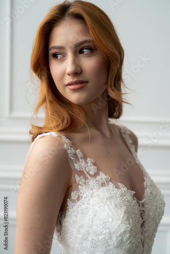 Beautiful young woman bride in fashion wedding dress in white interior
