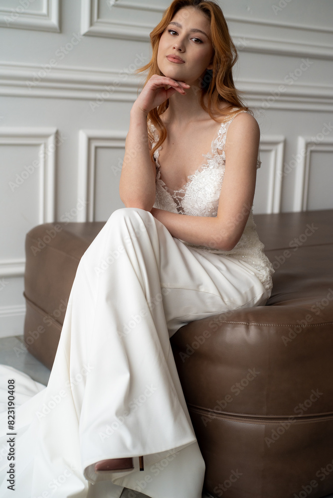 Beautiful young woman bride in fashion wedding dress in white interior Beautiful young woman bride in fashion wedding dress in white interior