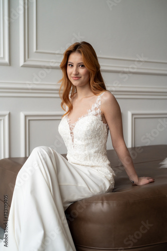 Beautiful young woman bride in fashion wedding dress in white interior © alipko
