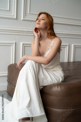 Beautiful young woman bride in fashion wedding dress in white interior