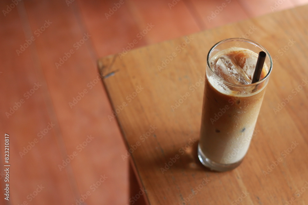 Iced milk coffee with palm sugar and straw on wooden table. Iced milk coffee with palm sugar and straw on wooden table.