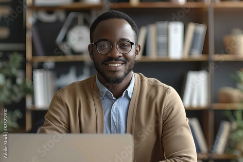 Man in glasses smiling at laptop desk