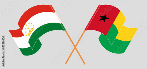 Crossed and waving flags of Tajikistan and Guinea-Bissau photo