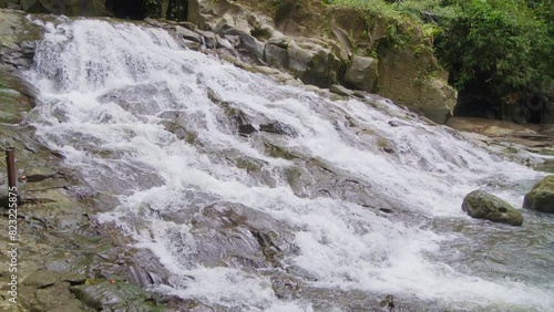 Goa Rang Reng waterfall on Bali island in Indonesia. Static slow-motion shot. photo