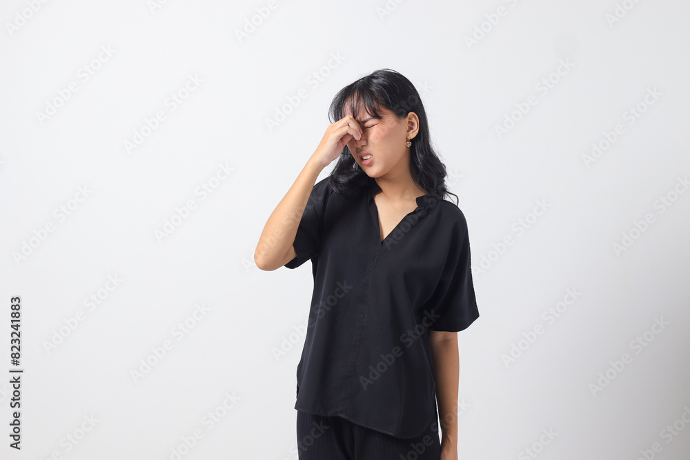 Portrait of overwhelmed Asian woman in casual shirt touching her head, having headache, and feeling stressed. Businesswoman concept. Isolated image on white background Portrait of overwhelmed Asian woman in casual shirt touching her head, having headache, and feeling stressed. Businesswoman concept. Isolated image on white background