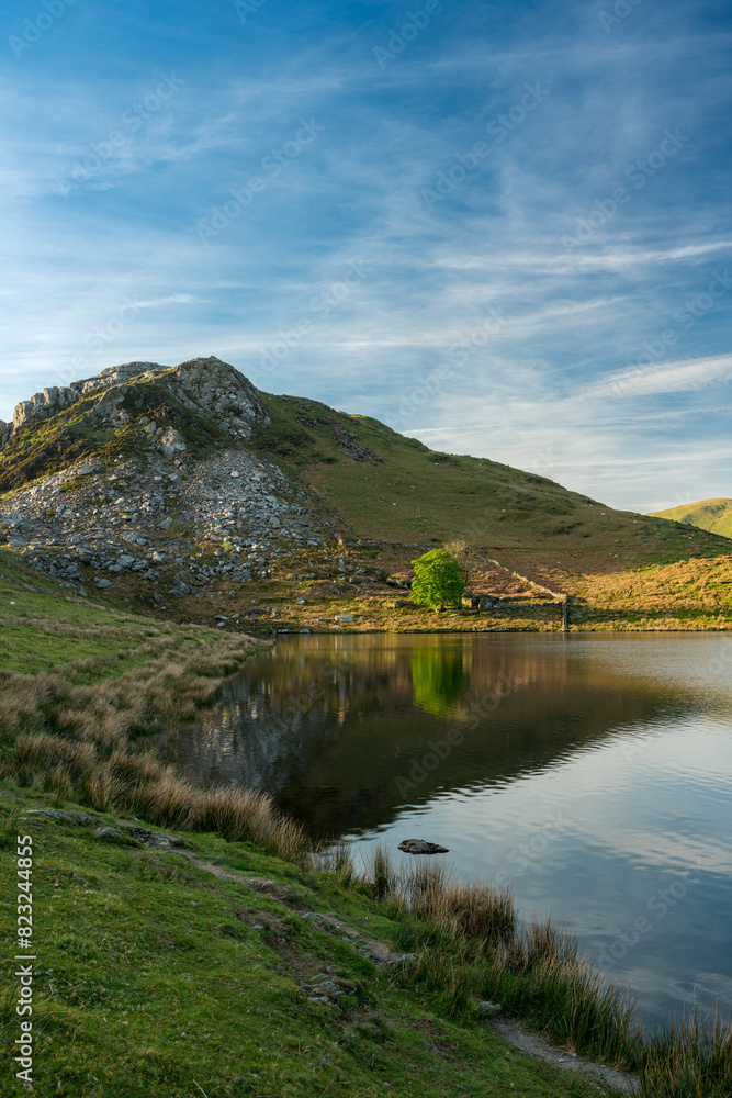 Sunset on Clogwyngarreg from Llyn Dywarchen in the Eryri National Park, Wales.