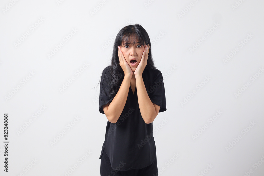 Portrait of attractive Asian woman in casual shirt making shocked hand gesture, showing surprised and scared expression. Isolated image on white background Portrait of attractive Asian woman in casual shirt making shocked hand gesture, showing surprised and scared expression. Isolated image on white background