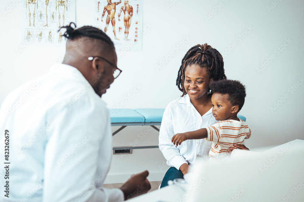 Obraz premium Stethoscope exam. Attractive cheerful male doctor listening to boy while putting on glasses and using stethoscope. Close up of a pediatrician having a check up on his patient. Pediatrician's Office