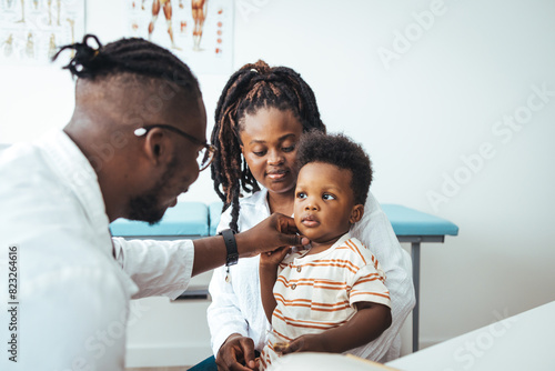 African male pediatrician hold stethoscope exam child boy patient visit doctor with mother, black paediatrician check heart lungs of kid do pediatric checkup in hospital children medical care concept photo