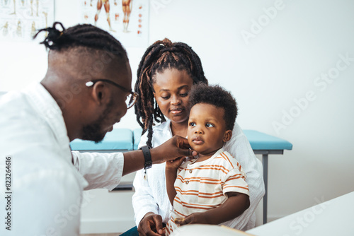 Tableau sur toile African male pediatrician hold stethoscope exam child boy patient visit doctor w