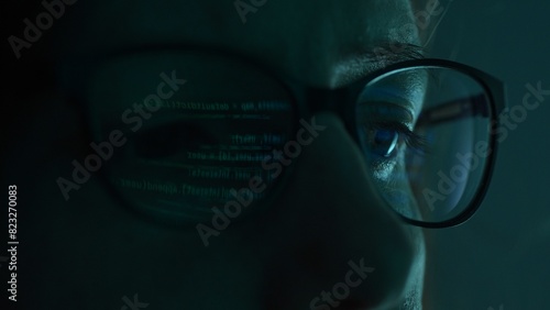 Fotografie Close-up view of a programmer's eyes, with code projected on their glasses in a dimly lit room