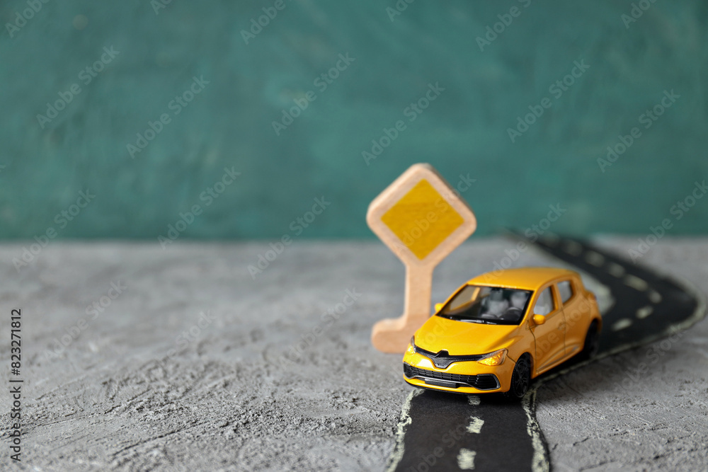 Yellow car on the road with a sign. Yellow car on the road with a sign.
