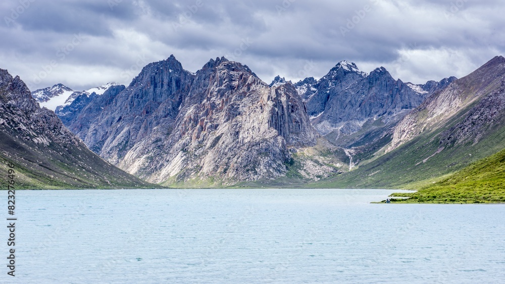 Breathtaking mountain landscape showcases a stunning body of vibrant blue water in the foreground Breathtaking mountain landscape showcases a stunning body of vibrant blue water in the foreground