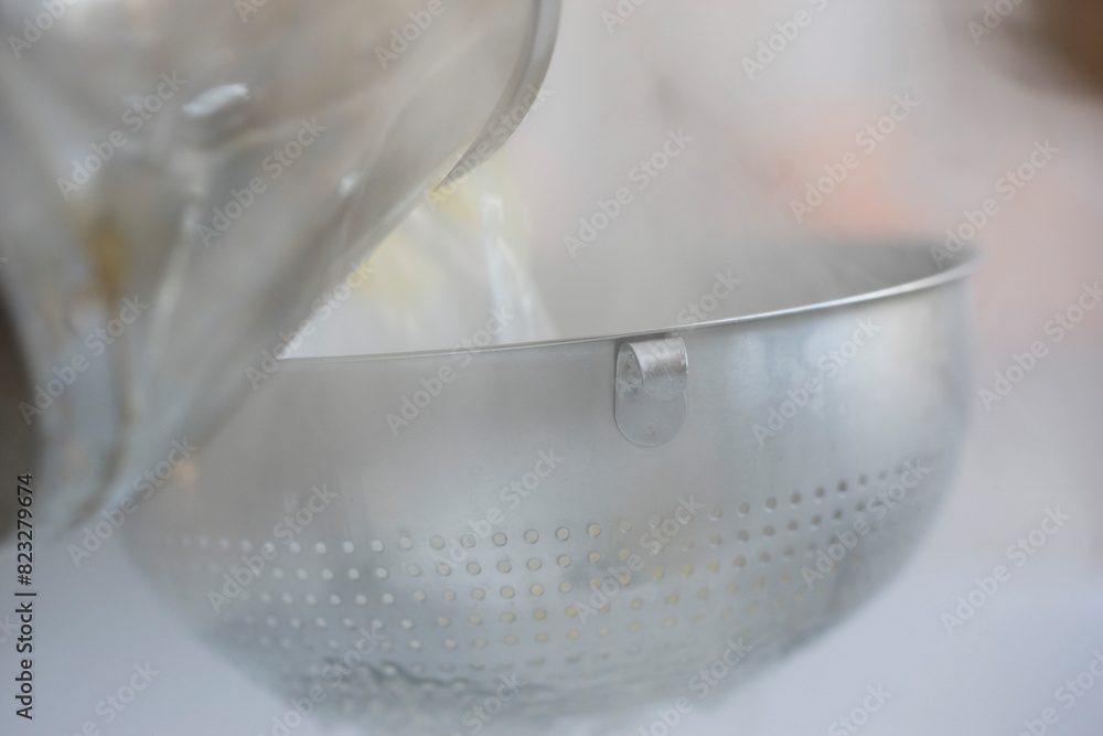 Pouring boiling water and pasta into a colander
Pouring boiling water and pasta into a colander