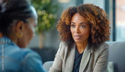 A lawyer sits, engaged in a confidential discussion. The blurred background suggests a professional setting, perhaps an office or meeting room.