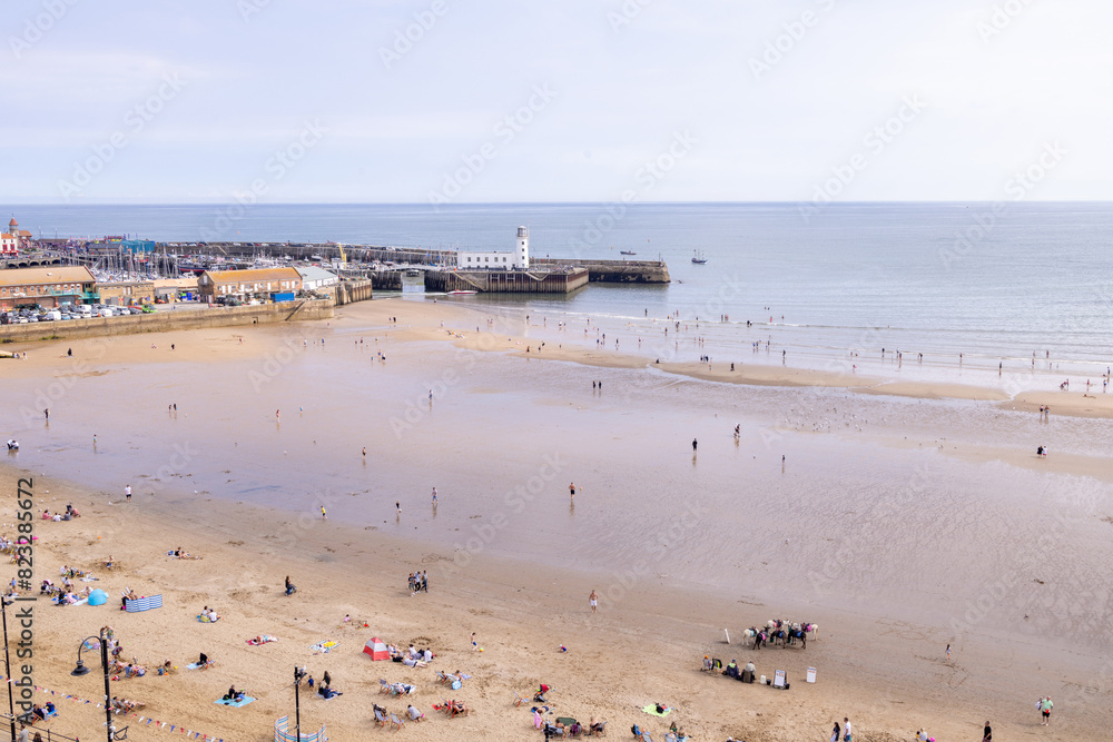 Aerial drone photo of the beach front in the town of Scarborough in North Yorkshire, England UK showing people relaxing and having fun on the British beach on a sunny summers day Aerial drone photo of the beach front in the town of Scarborough in North Yorkshire, England UK showing people relaxing and having fun on the British beach on a sunny summers day
