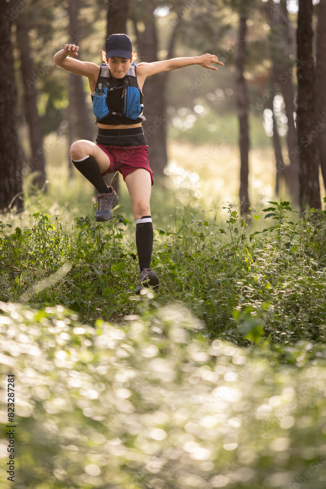 A woman is jumping in the woods with her legs apart A woman is jumping in the woods with her legs apart