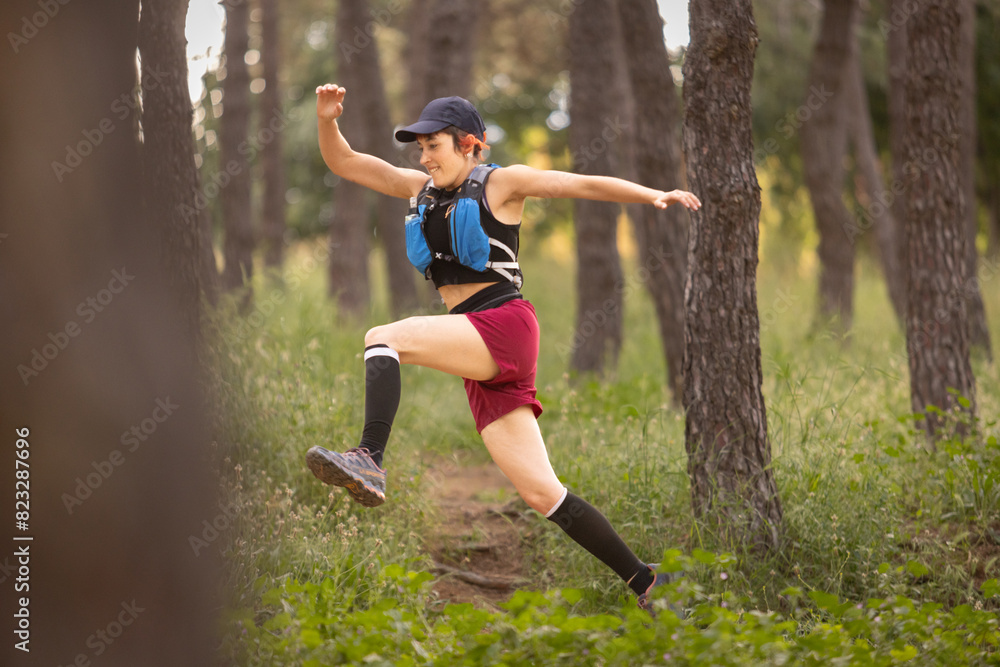 A woman is running through a forest with a backpack on