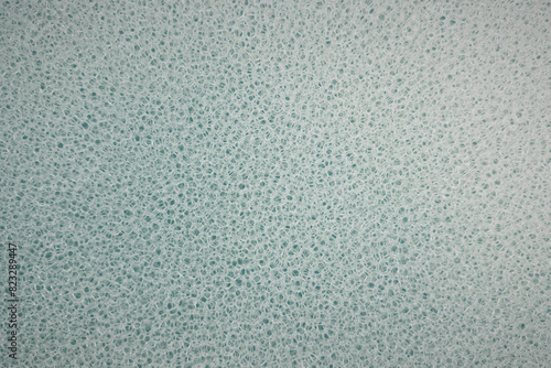 Full frame close up detail holes in pale blue sponge
 photo