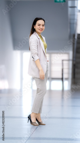 A woman in a business suit stands in a hallway