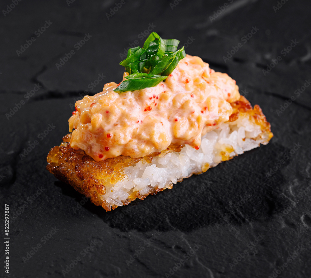 Delectable spicy sushi roll on slate background Delectable spicy sushi roll on slate background