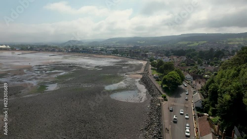 Drone flight along Minehead Beach in Somerset in the UK showcasing a road and mountain on cloudy day photo