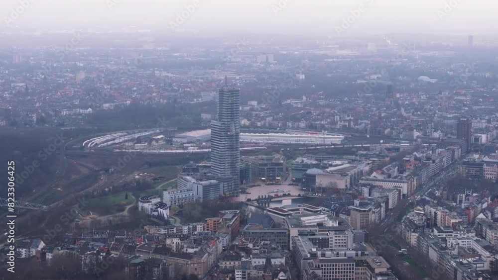 Breathtaking aerial shot of Cologne Tower, showcasing a mix of modern architecture and urban scenery against a peaceful cloudy sky Breathtaking aerial shot of Cologne Tower, showcasing a mix of modern architecture and urban scenery against a peaceful cloudy sky