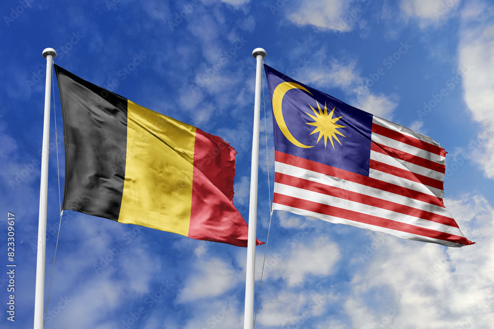 3d illustration. Belgium and Malaysia Flag waving in sky. High detailed waving flag. 3D render. Waving in sky. Flags fluttered in the cloudy sky.