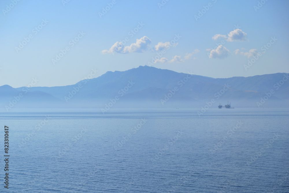 the marine oil extraction platform in the morning fog; the island of Thassos in the background - aegean sea the marine oil extraction platform in the morning fog; the island of Thassos in the background - aegean sea