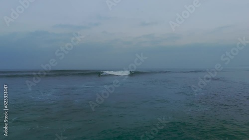 Aerial shot of surfer surfing on wave between group surfer in Atlantic Ocean during sunset time at Baleal Beach, Portugal