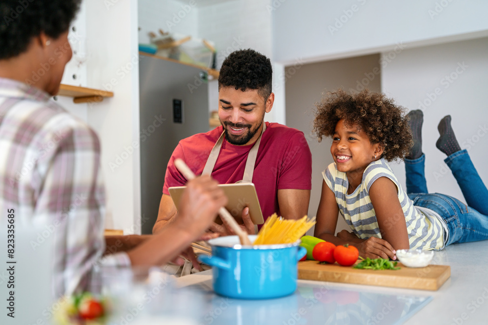 Happy african american family preparing healthy food in kitchen, having fun together on weekend Happy african american family preparing healthy food in kitchen, having fun together on weekend
