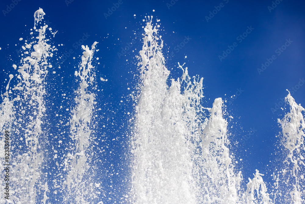 Liquid spraying from fountain against electric blue sky in natural landscape Liquid spraying from fountain against electric blue sky in natural landscape