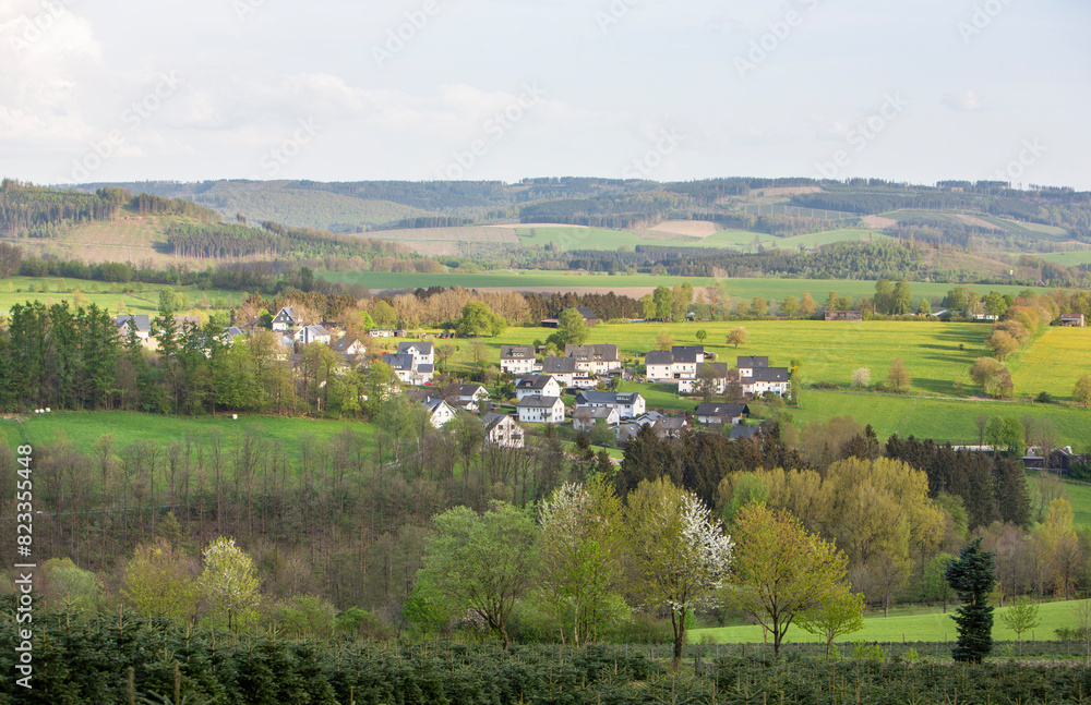 white houses in village near schmallenberg in spring and surrounding countryside