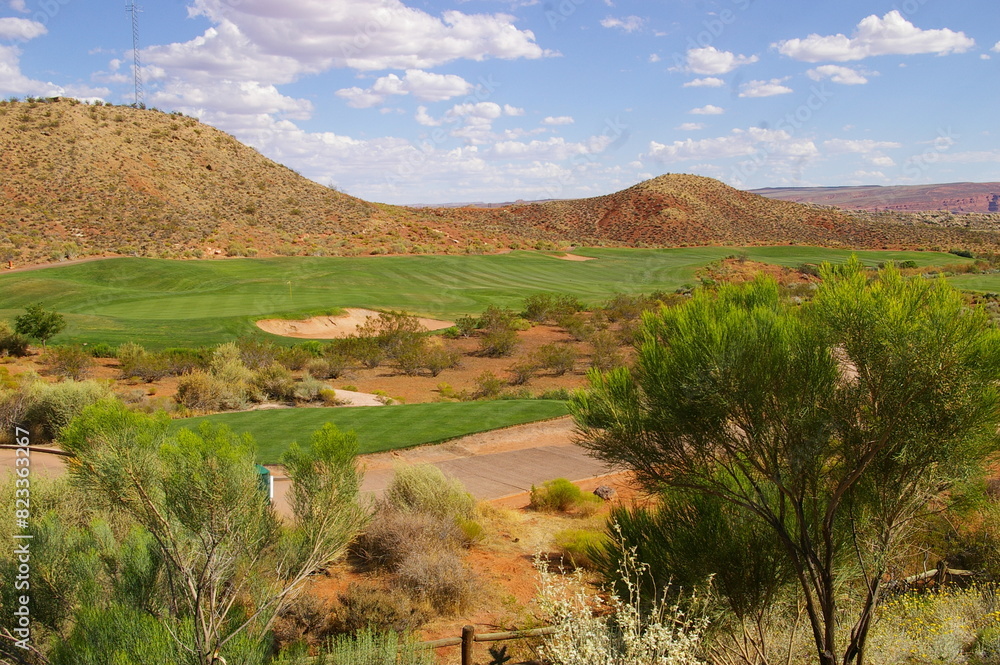 Naklejka premium Scenic view from hilltop of golf course, mountains, and clear blue sky in Utah