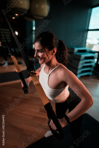 Beautiful woman doing exercise with trx system.Fitness exercises with loops.Concept workout healthy lifestyle sport.