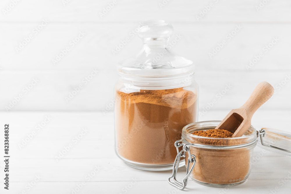 Cinnamon powder in a bowl on a textured wooden background. Spicy spice for baking, desserts and drinks. Fragrant ground cinnamon. Cinnamon stick. Place for text. Copy space. Cinnamon powder in a bowl on a textured wooden background. Spicy spice for baking, desserts and drinks. Fragrant ground cinnamon. Cinnamon stick. Place for text. Copy space.