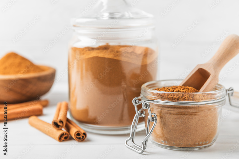 Cinnamon powder in a bowl on a textured wooden background. Spicy spice for baking, desserts and drinks. Fragrant ground cinnamon. Cinnamon stick. Place for text. Copy space. Cinnamon powder in a bowl on a textured wooden background. Spicy spice for baking, desserts and drinks. Fragrant ground cinnamon. Cinnamon stick. Place for text. Copy space.