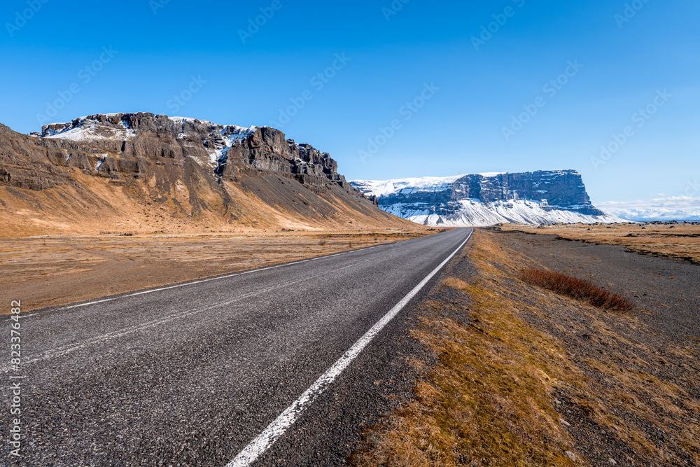 Country road with majestic cliffs in the background. Iceland Country road with majestic cliffs in the background. Iceland