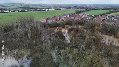 view from above of the water and fields near houses, trees and bushes photo