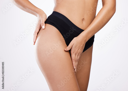 Underwear, hands and woman in studio for legs, diet or lose weight on stomach isolated on white background. Panties, skin and model touch slim thigh to check cellulite, health or wellness of buttocks
