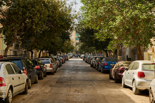 Fototapeta Naklejka Na Ścianę i Meble -  Narrow street full of cars in warm colors, Athens, Ecology problem