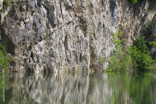 Old quarry lake with rocks reflected in the water
