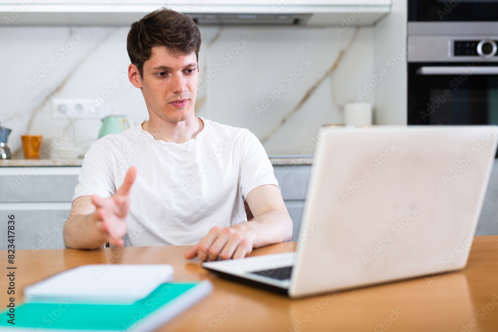 Young guy studying at home with laptop Young guy studying at home with laptop