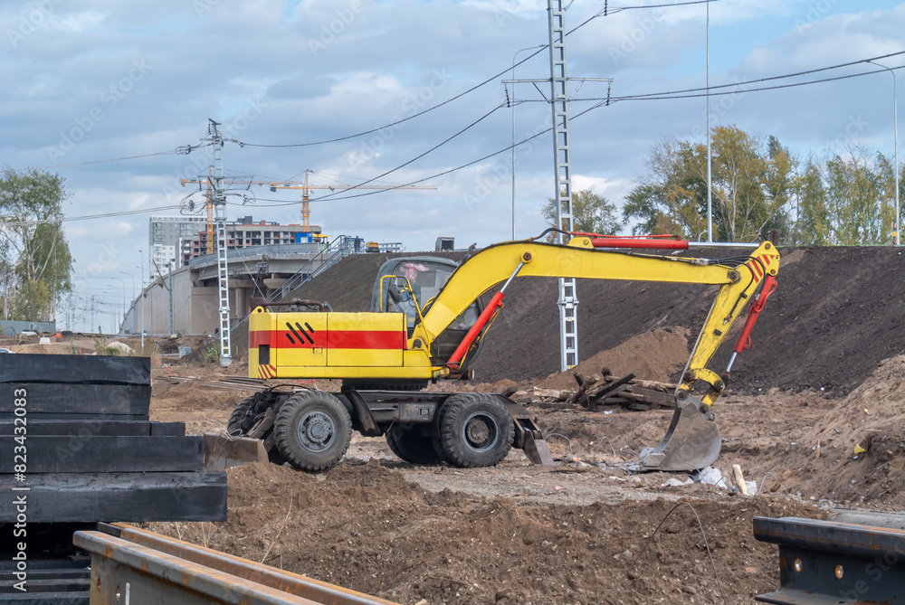 A wheeled excavator for road construction. Equipment for digging trenches. Equipment for road and construction work. The bucket of the excavator. Construction of road bridges. A wheeled excavator for road construction. Equipment for digging trenches. Equipment for road and construction work. The bucket of the excavator. Construction of road bridges.