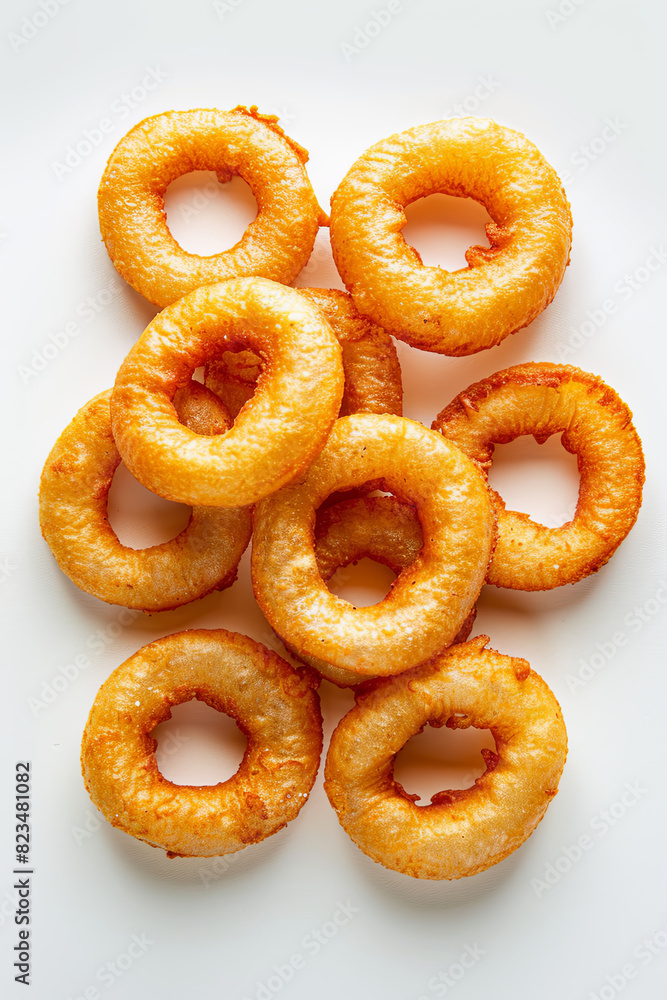 Crispy golden-brown onion rings arranged against white backdrop