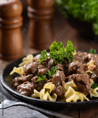 Beef stroganoff with egg noodles garnished with parsley